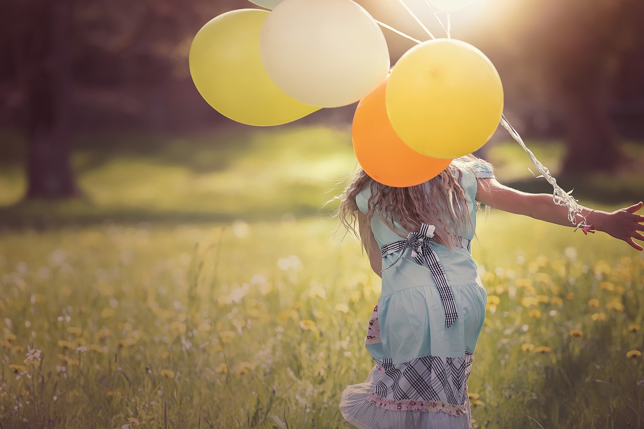 dziewczynka biegnąca z balonami